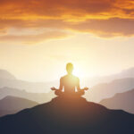 Silhouette of the meditaion man on the mountain