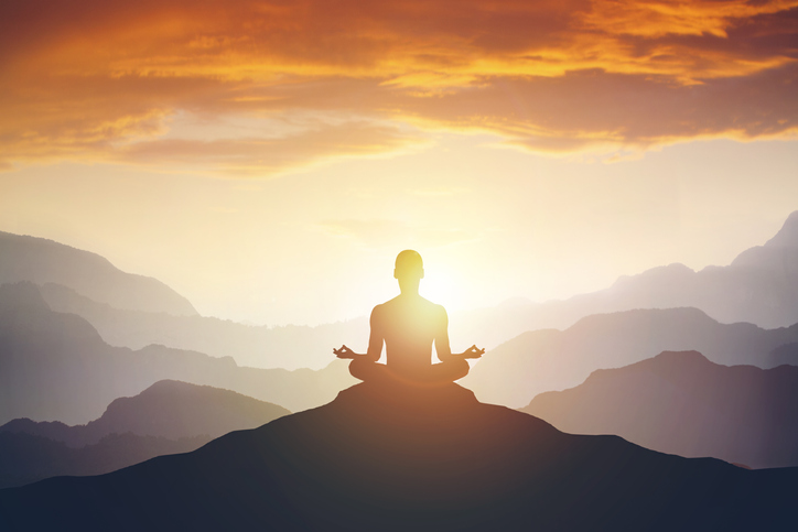 Silhouette of the meditaion man on the mountain